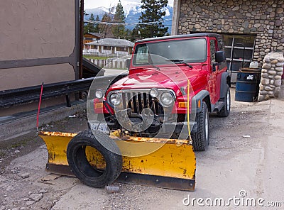 A sturdy vehicle equipped for serious snow removal parked outside a house in alaska Editorial Stock Photo