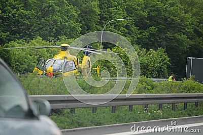 STUTTGART, GERMANY - June, 2016: A rescue helicopter on the Autobahn during an accident. Evacuation of victims. Editorial Stock Photo