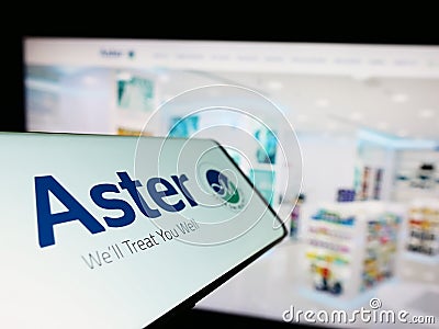 Mobile phone with logo of health company Aster DM Healthcare Limited on screen in front of business website. Editorial Stock Photo