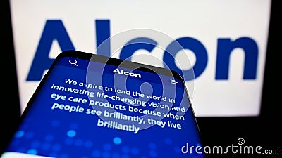 Mobile phone with website of eye care company Alcon AG on screen in front of business logo. Editorial Stock Photo
