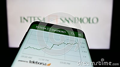 Mobile phone with website of Italian banking company Intesa Sanpaolo S.p.A. on screen in front of logo. Editorial Stock Photo