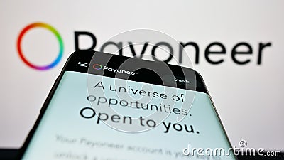 Mobile phone with website of payments company Payoneer Global Inc. on screen in front of logo. Editorial Stock Photo