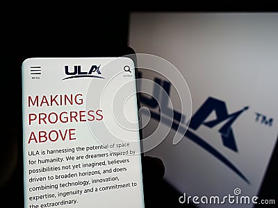 Person holding cellphone with webpage of US space company United Launch Alliance (ULA) on screen with logo. Editorial Stock Photo