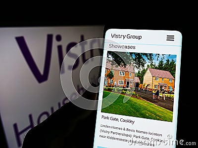 Person holding smartphone with website of British housebuilding company Vistry Group plc on screen with logo. Editorial Stock Photo