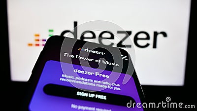 Smartphone with website of French music streaming company Deezer S.A. on screen in front of business logo. Editorial Stock Photo