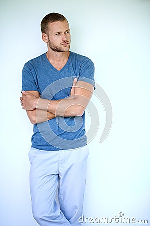 Style kept simple. Studio shot of a handsome young man posing against a white background. Stock Photo