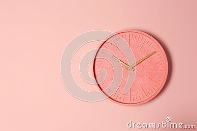 Stylish analog clock hanging on color wall. Stock Photo