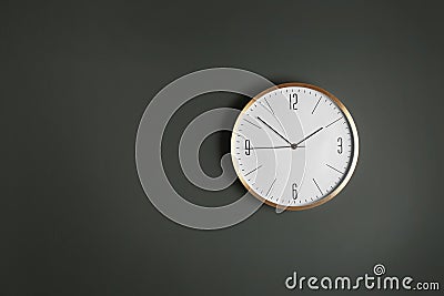 Stylish analog clock hanging on gray wall, space for text. Stock Photo