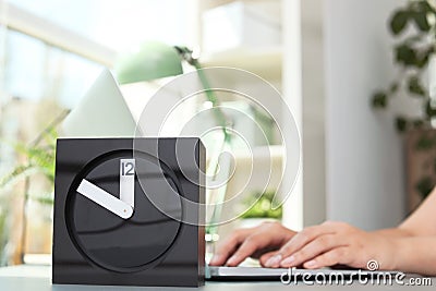 Stylish analog clock on table in office Stock Photo