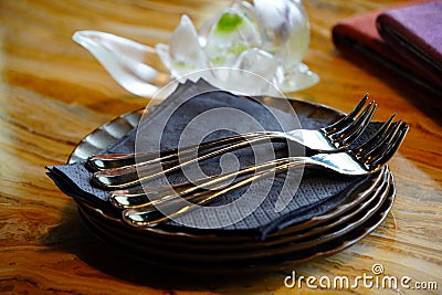 Stylish arrangement of four white plates with forks on top of them Stock Photo