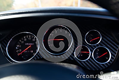 Stylish backlit dashboard with sensors for measuring speed, engine temperature and pressure against a blue and black chess Stock Photo