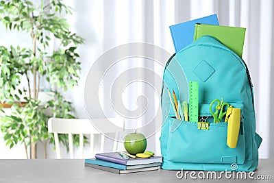 Stylish backpack with different school stationery on table. Space for text Stock Photo