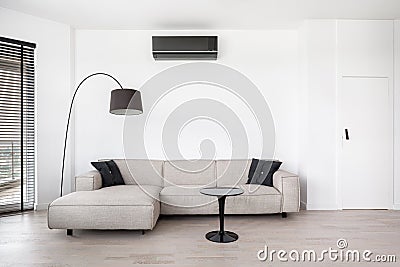 Stylish, beige corner sofa in white living room Stock Photo