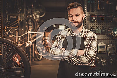 Stylish bicycle mechanic standing in his workshop. Stock Photo