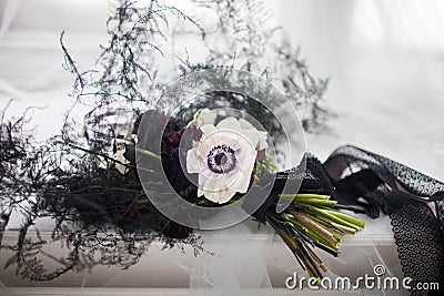 Stylish black bouquet tied with a black ribbon on a white cloth Stock Photo