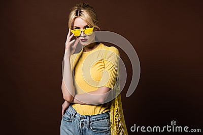 stylish blonde girl with string bag wearing yellow sunglasses and looking at camera Stock Photo