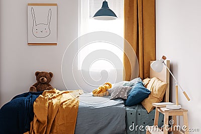 Stylish blue and orange kid`s bedroom design in bright apartment Stock Photo