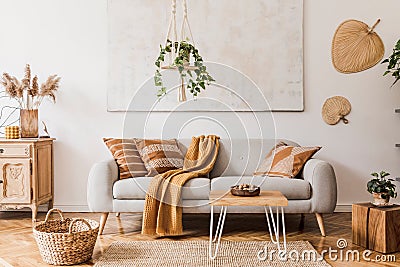 Modern boho interior of living room at cozy apartment with gray sofa. Stock Photo