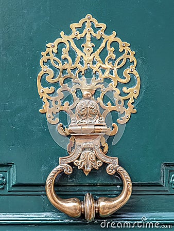 Stylish brass doorknocker on green wooden door Stock Photo