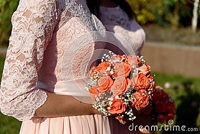 Stylish bridesmaids in pink lace dress holding amazing bouquets Stock Photo