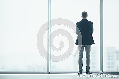 Stylish business man in the background of a large window in office Stock Photo