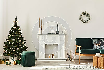 Stylish christmas living room interior with green sofa, white chimney, christmas tree and wreath, gifts and decoration. Stock Photo