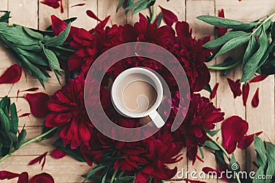 stylish coffee and beautiful red peonies on rustic wooden background flat lay. space for text. modern floral instagram blogging i Stock Photo