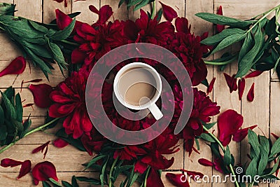 stylish coffee and beautiful red peonies on rustic wooden background flat lay. space for text. modern floral instagram blogging i Stock Photo