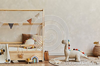 Stylish composition of cozy scandinavian child`s room interior with wooden bed, pillows, plush dinosaur, wooden toys and textile. Stock Photo
