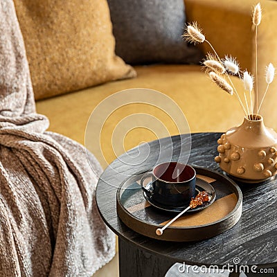 Stylish composition of modern living room. Stylish coffe table with tray, cup and yellow vase with dried flowers. Template Stock Photo