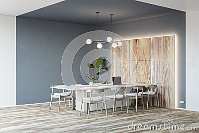 Stylish conference room with eco decoration, perspective view on modern laptop on light meeting table surrounded by chairs on Stock Photo