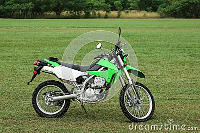 Stylish cross motorcycle on green grass outdoors Stock Photo