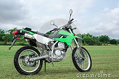 Stylish cross motorcycle on green grass outdoors Stock Photo