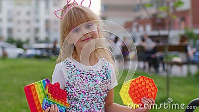 Stylish cute child kid girl showing squishy silicone touch screen bubbles pop it sensory game toys Stock Photo