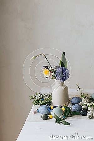 Stylish easter eggs and spring flowers on rustic wooden table. Happy Easter! Natural dye marble and blue eggs, purple hiacynt Stock Photo