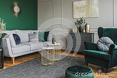 Stylish emerald green and grey living room interior design with abstract painting on the wall Stock Photo