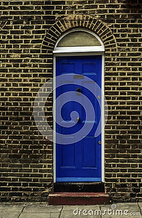 stylish entrance to a residential building, an interesting facade of the old brick arches above the door, a typical old English b Stock Photo