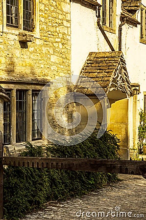 stylish entrance to a residential building, an interesting facade of the old stone wall, old wooden door, typical old English bu Stock Photo