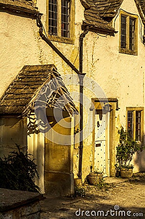 stylish entrance to a residential building, an interesting facade of the old stone wall, old wooden door, typical old English bu Stock Photo