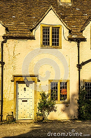 stylish entrance to a residential building, an interesting facade of the old stone wall, old wooden door, typical old English bu Stock Photo