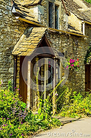 stylish entrance to a residential building, an interesting facade of the old stone wall, old wooden door, typical old English bu Stock Photo