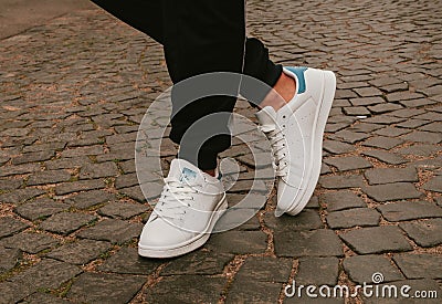 Stylish fashionable white womens leather shoes. Womens legs with sneaker Stock Photo