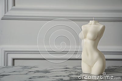 Stylish female body shaped candle on white marble table. Space for text Stock Photo