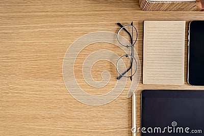 Stylish flat lay business composition on the wooden desk with glasses, notes, pen, copy space and office supplies . Stock Photo