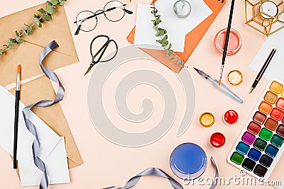 Stylish flatlay with art supplies, envelopes, brushes, watercolors, glasses, pen and other stationary and art supplies Stock Photo