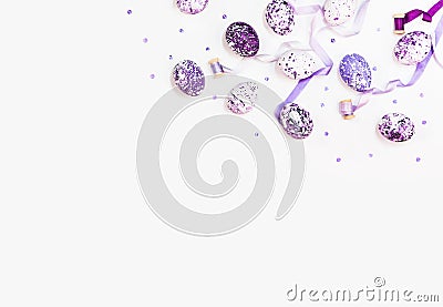 Stylish frame background with easter eggs and silk ribbons. Purple, lilac and white easter eggs with copy space for text. Isolated Stock Photo