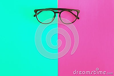 stylish glasses on a bright green-cyan and crimson-pink background, top view, isolated. Copy space. Flat lay Stock Photo