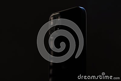 stylish glossy rectangular smartphone with two cameras on a black isolated background close-up. Stock Photo