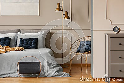 Stylish golden lamp next to king size bed with blue bedding and dark blue pillows Stock Photo