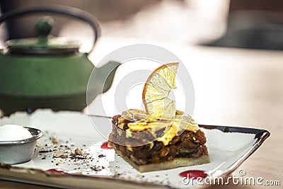 green kettle with tea and sweet dessert. Caramelized Apple Pie with Lemon and Cold Ice Cream Stock Photo